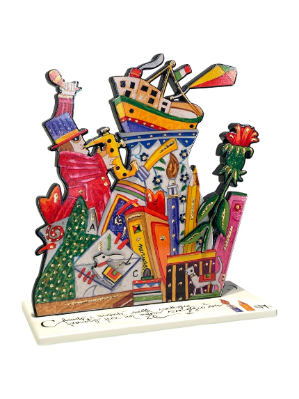 Chiudo i ricordi nella valigia di Francesco Musante, scultura in resina in edizione limitata con valigia, libri, nave e simboli del viaggio.