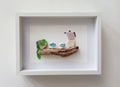 Quadro realizzato a mano con vetri di mare raffigurante una caffettiera e tazzine su un legno di mare, stile minimalista per arredamento casa.